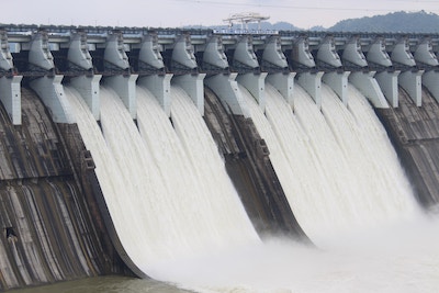 Staudamm aus dem durch neun Durchgängen Wasser schießt
